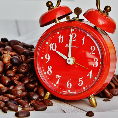 Coffee beans and a red clock. Photo: Pixabay.