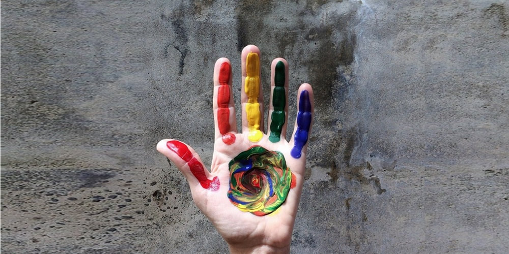A hand with colourful painting on it, photo by Wokandapix from Pixabay