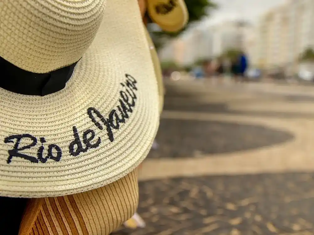 Straw hats with Rio de Janeiro lettering in an outdoor setting in Rio de Janeiro.
