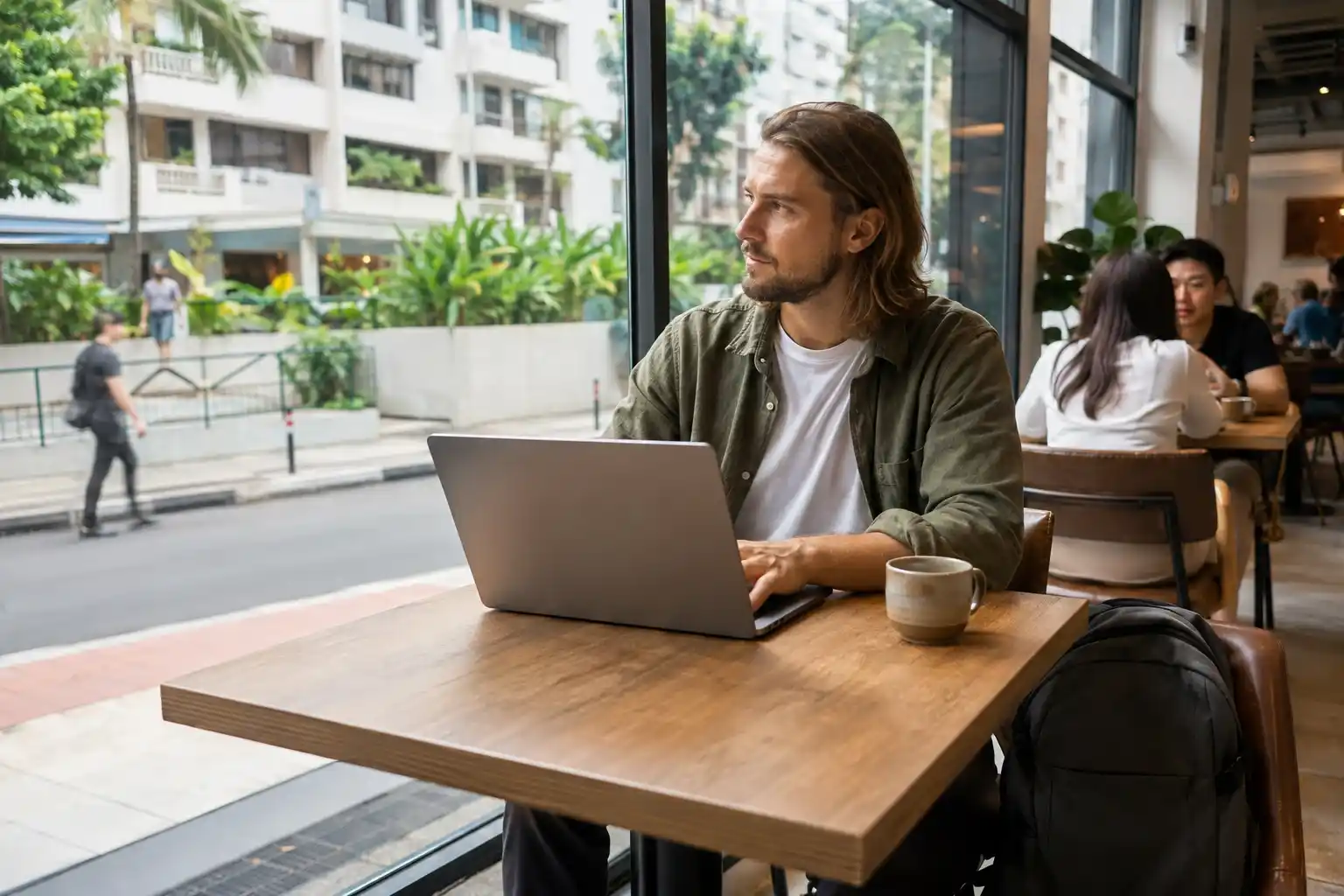 Male digital nomad working on a laptop in an ordinary café in Singapore.