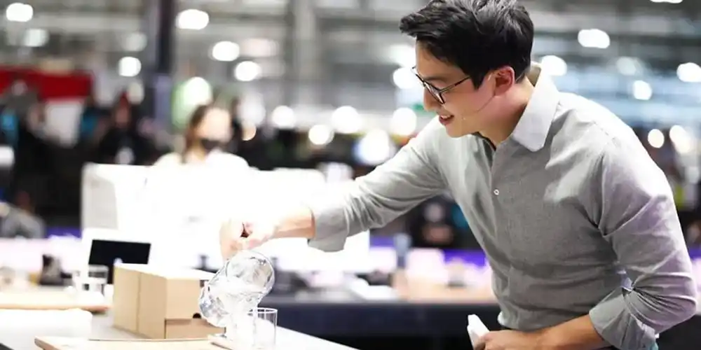 Boram Um preparing coffee behind a competition counter at a barista event.