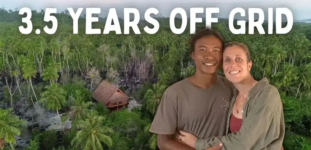 Thumbnail Our Island Life: Marjolein dan Adrianus tersenyum di depan pondok jerami di hutan, berjudul 3.5 Years Off Grid.