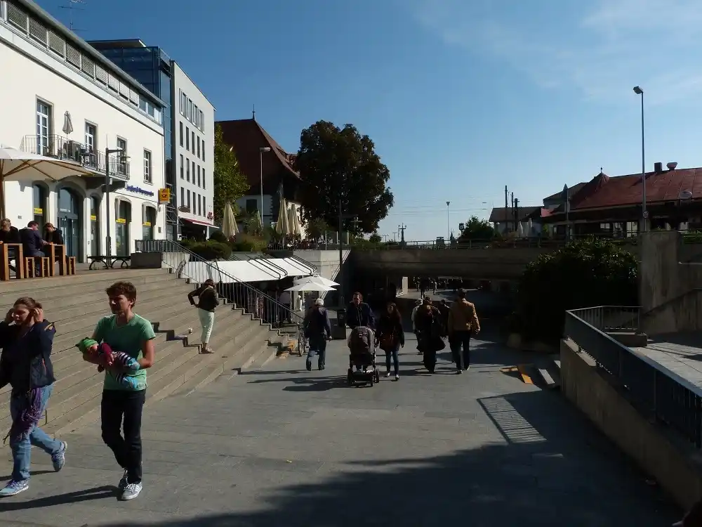 People strolling past shops and cafés in Konstanz.