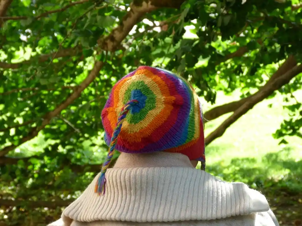 Person wearing a colourful hat in a green garden setting on Mainau Island.