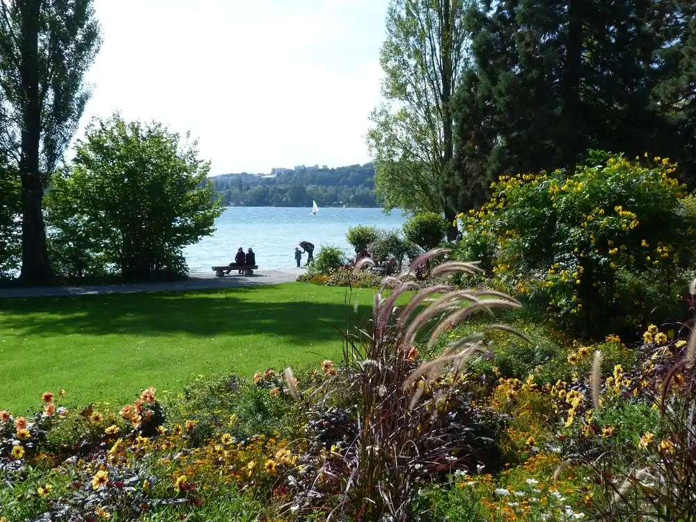 Lakeside garden with flowers and trees on Mainau Island overlooking Lake Constance.