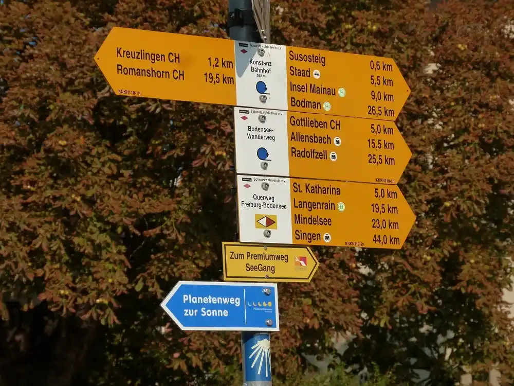 Yellow direction signs showing routes and distances near Konstanz.