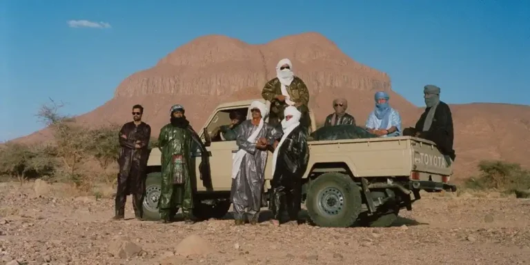 Members of Tuareg band Tinariwen in the Sahara desert near the Hoggar Mountains in southern Algeria. © Marie Planeille, press photo Tinariwen.