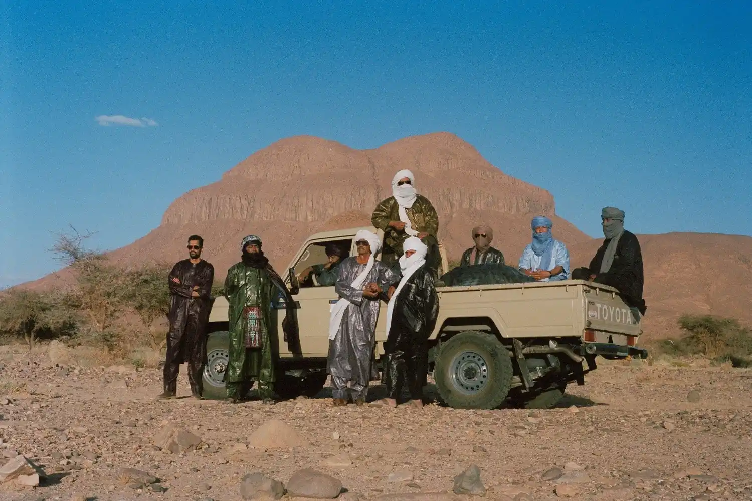 Members of Tuareg band Tinariwen in the Sahara desert near the Hoggar Mountains in southern Algeria. © Marie Planeille, press photo Tinariwen.