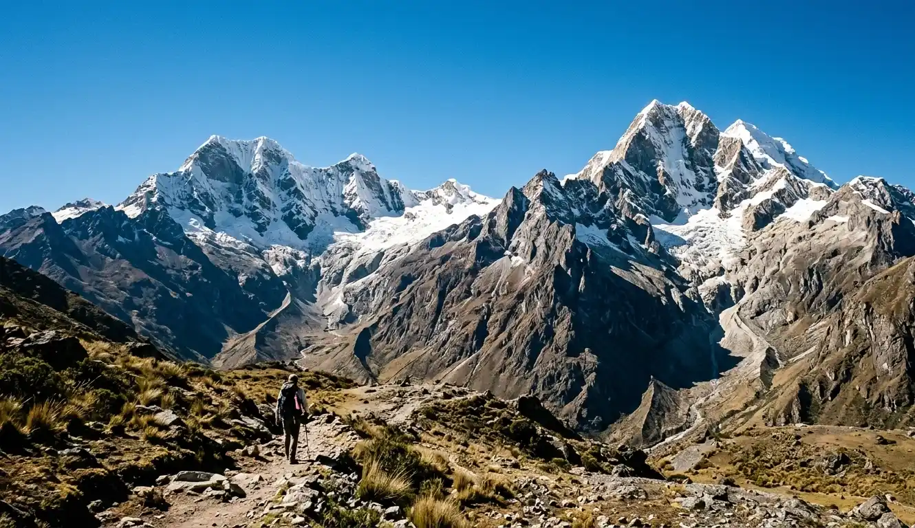 Sharp Andean mountain peaks in Peru under clear morning light with blue sky and light snow.