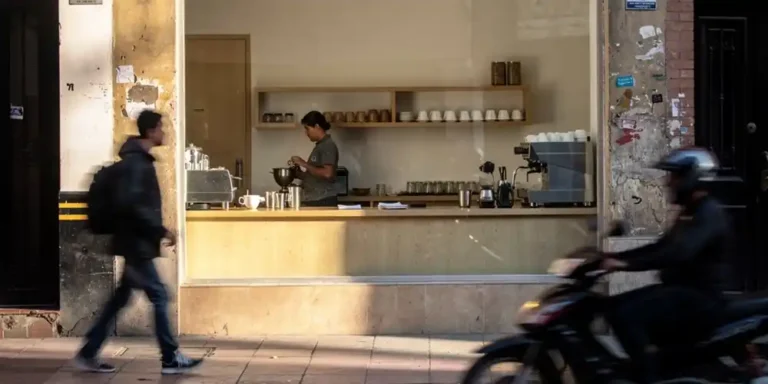 Street view of a Bogotá café with a barista visible inside.