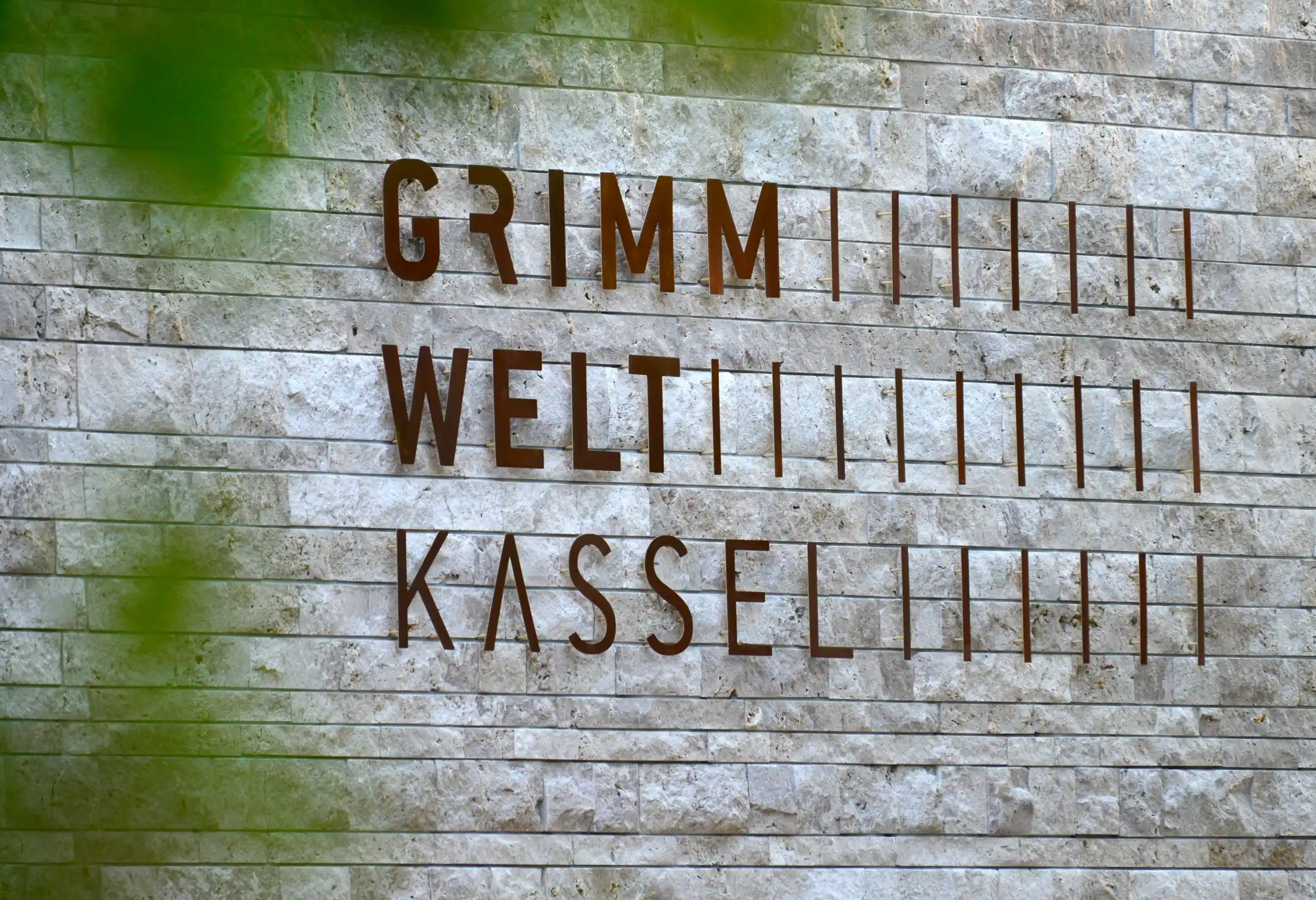 GRIMMWELT Kassel museum exterior sign on stone wall in Kassel Germany.