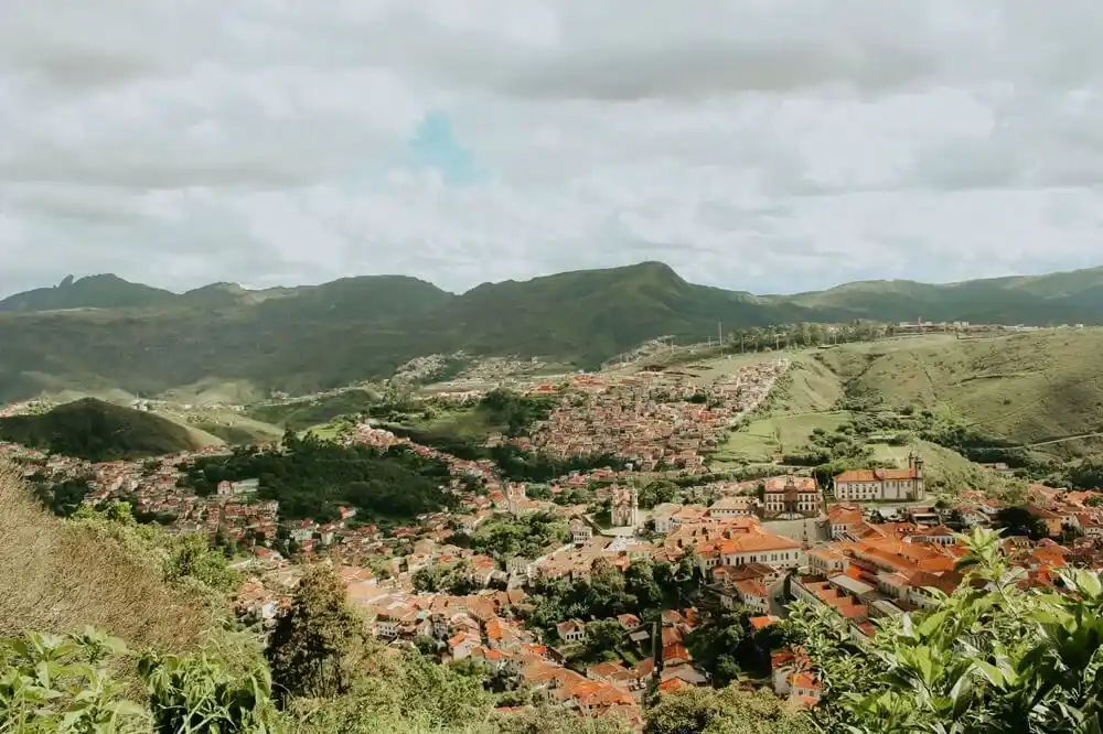 Panoramic view of Ouro Preto with red rooftops and green hills in Minas Gerais.