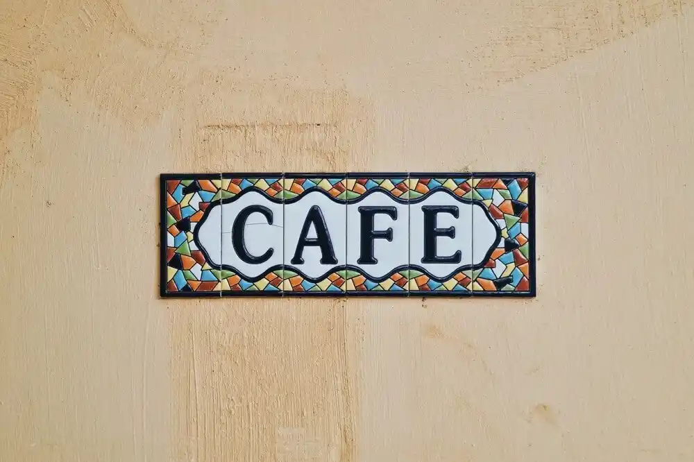 Colourful ceramic cafe sign on a wall in Brazil.